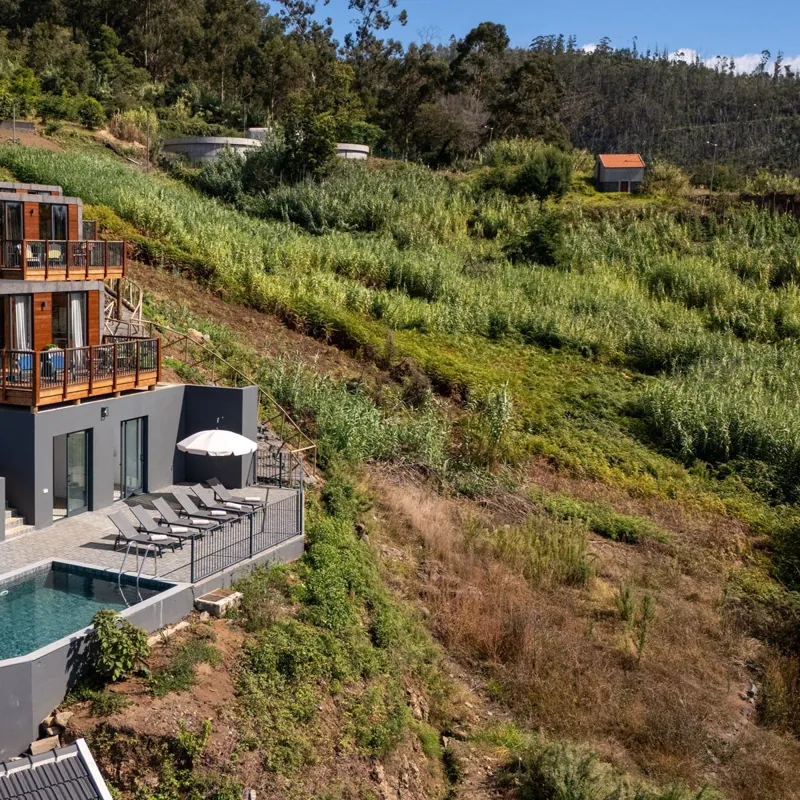 Vista aérea dos lodges e da piscina na encosta