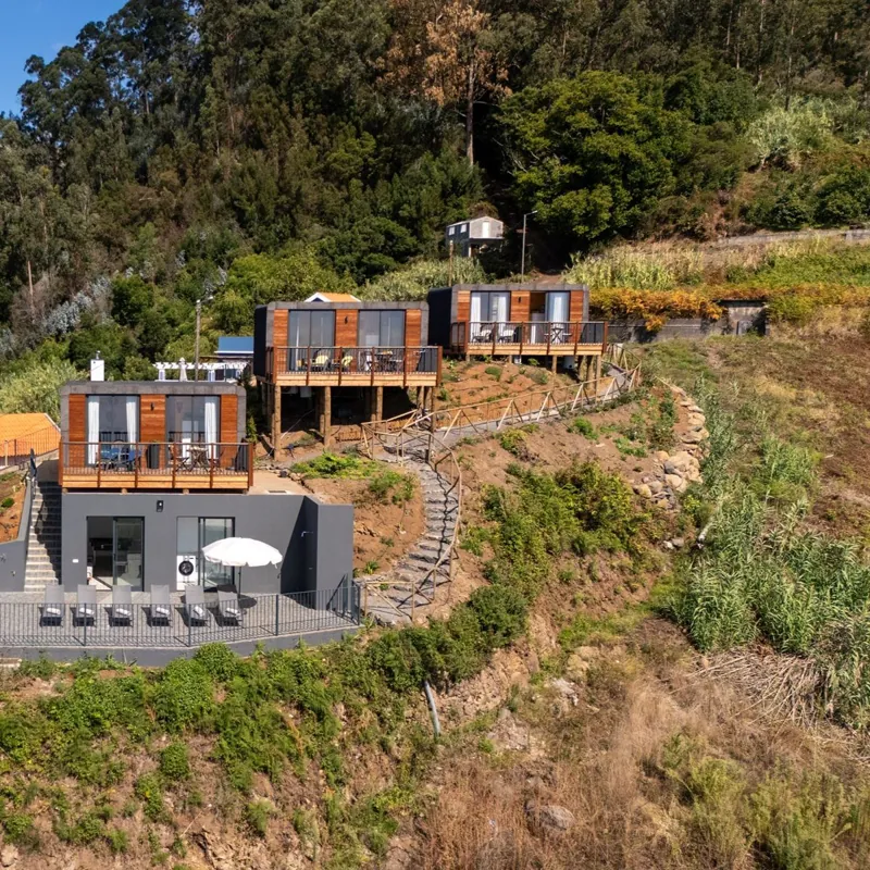 Os três lodges na encosta, ligados por um caminho