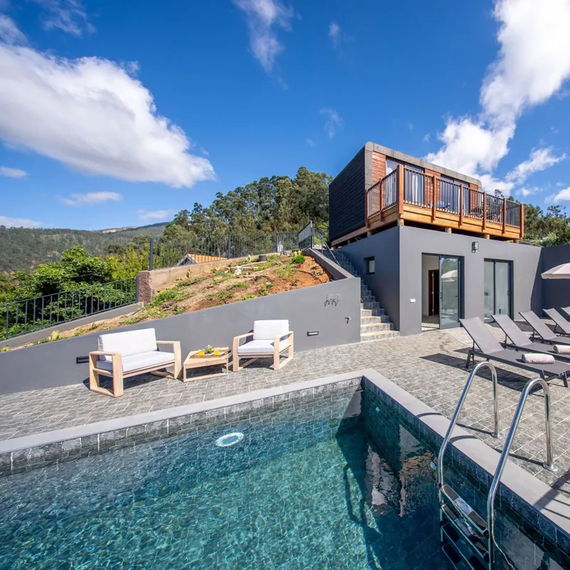 Piscina com cadeiras e lodge ao fundo