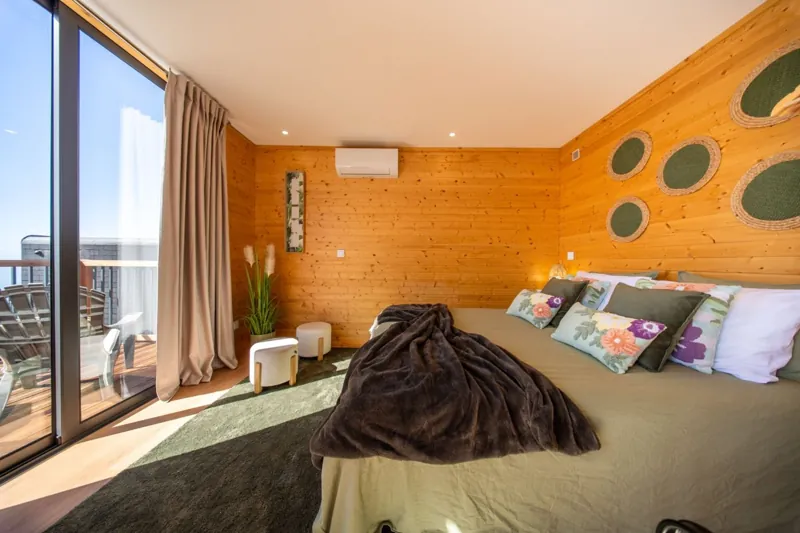 Quarto com porta de vidro para a varanda e vista de oceano