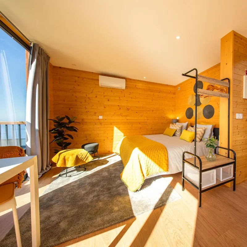 Quarto com cama de casal e luz do sol