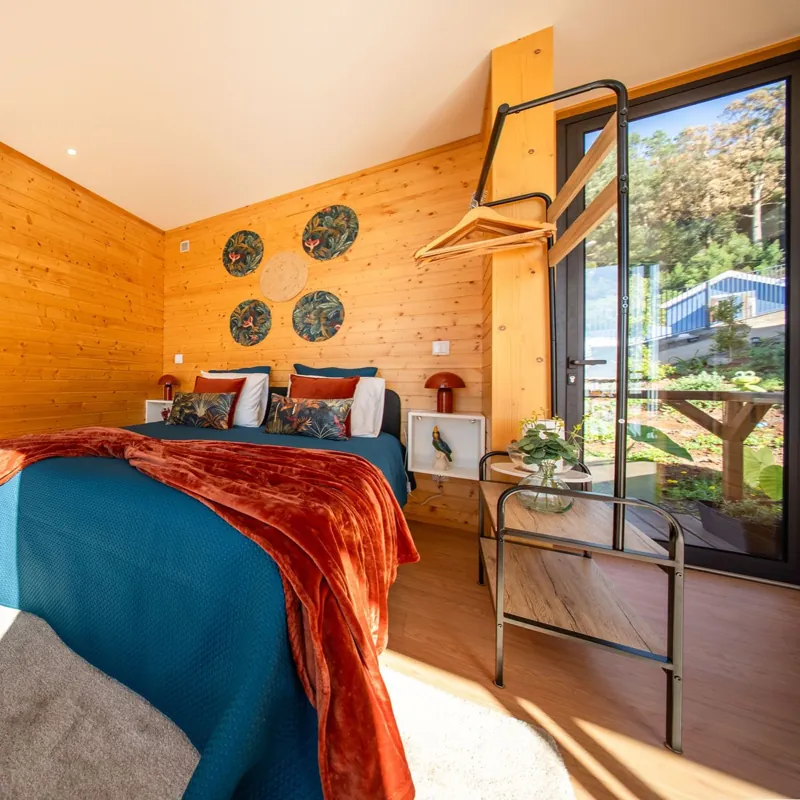 Quarto com cama queen e porta de vidro para o jardim