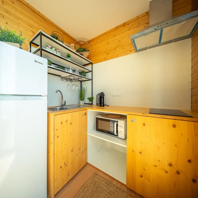 Cozinha equipada com frigorífico, micro-ondas, placa e máquina de café